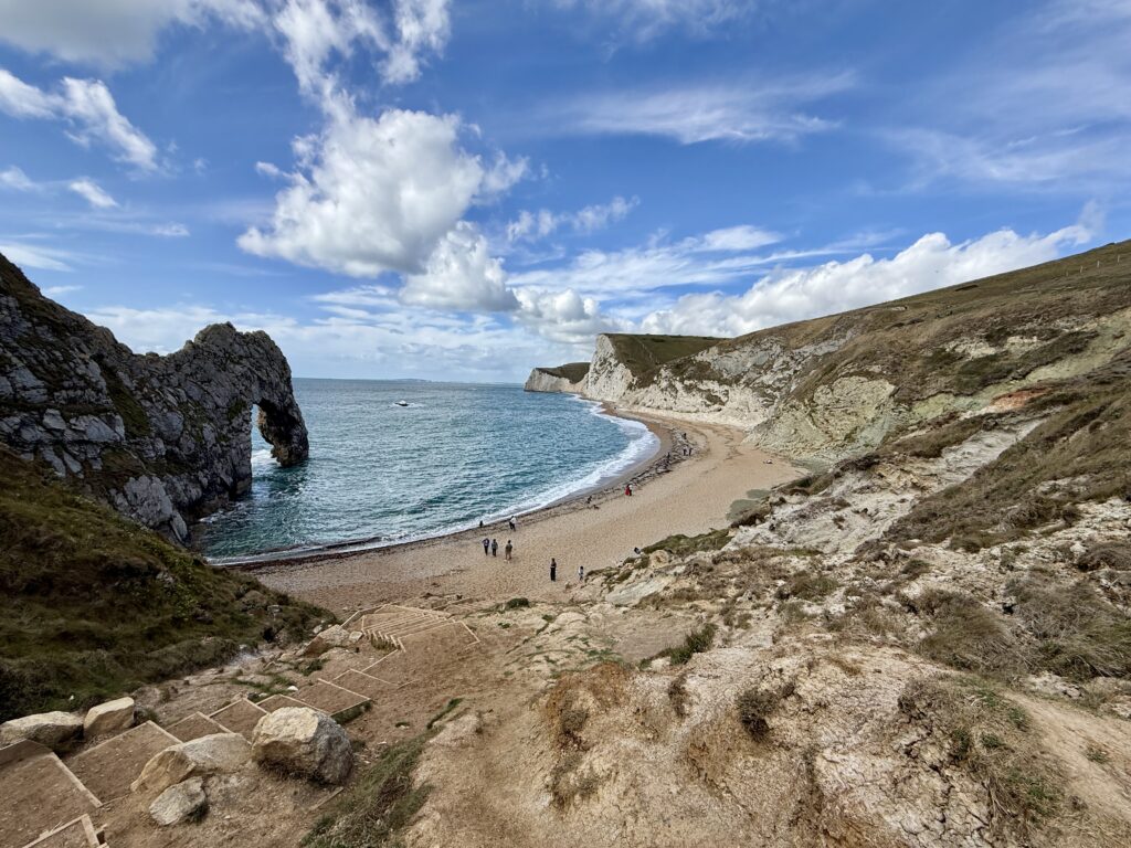 Durdle Door and the Jurassic Coast in Dorset, with the limestone arch, beach and cliffs overlooking the sea.