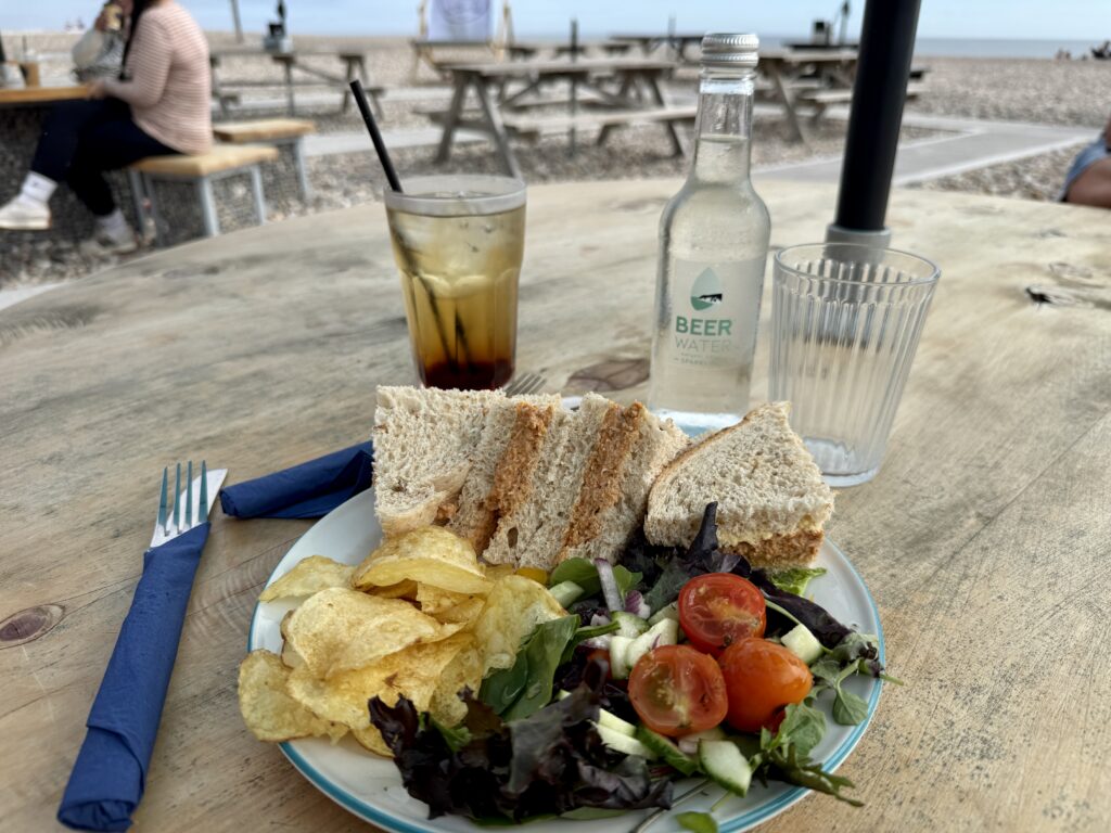Crab sandwiches served with crisps and salad at a beach café overlooking Beer Beach in Devon.