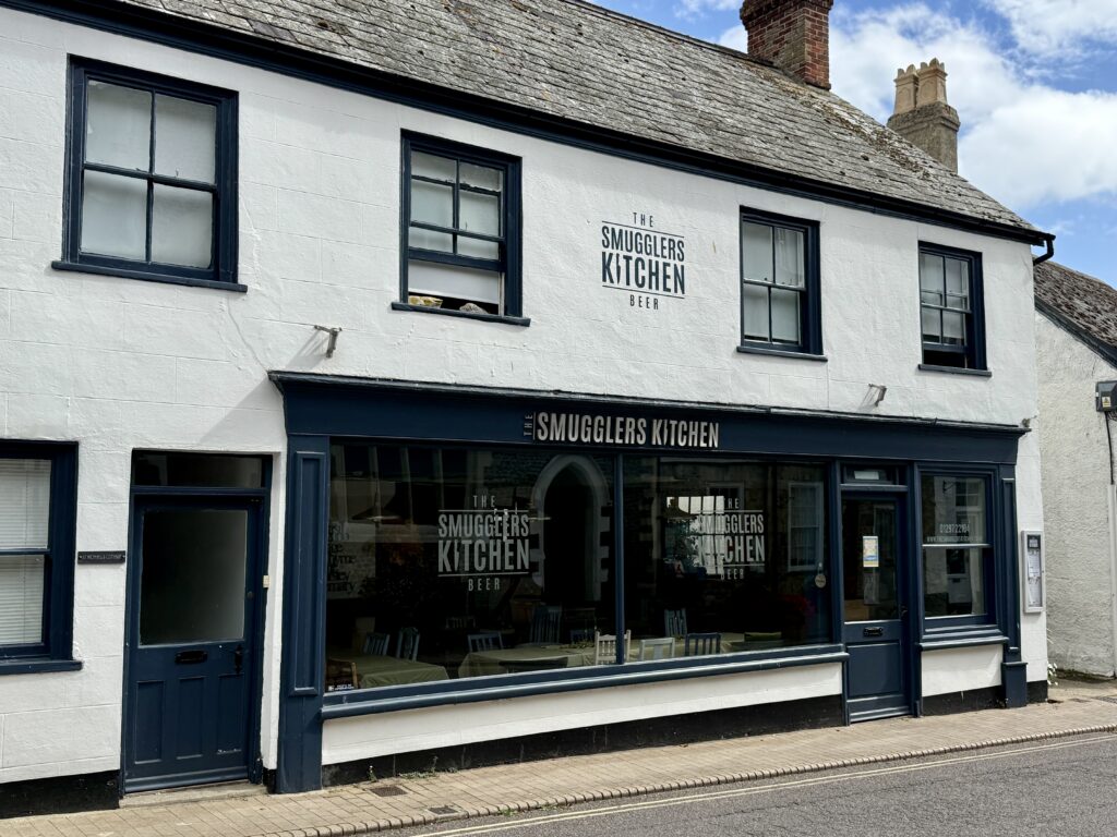 The Smugglers Kitchen restaurant in a traditional white building on Fore Street in Beer, Devon.