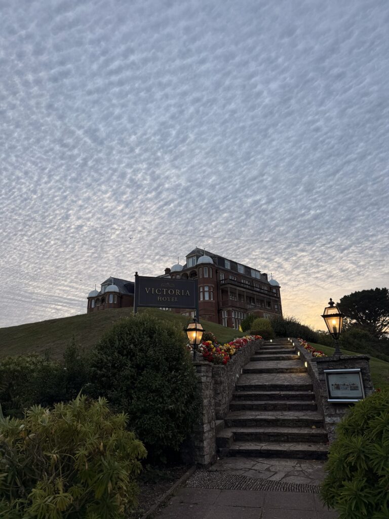 The Victoria Hotel in Sidmouth overlooking the Jurassic Coast at sunset, one of the popular places to stay during the Sidmouth Folk Festival in East Devon.