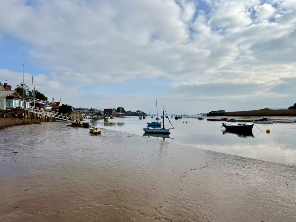 Boats moored on the River Exe beside Topsham waterfront at low tide