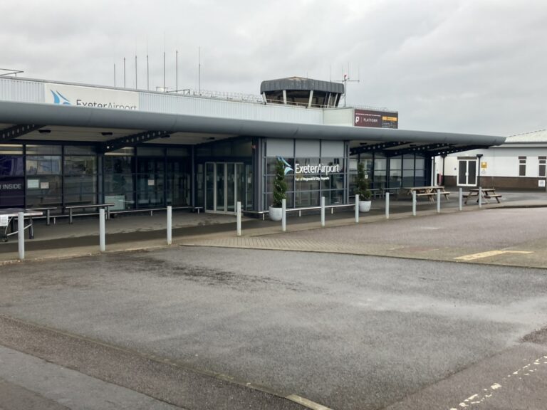 Entrance to Exeter Airport departures, showing the main terminal exterior and signage.