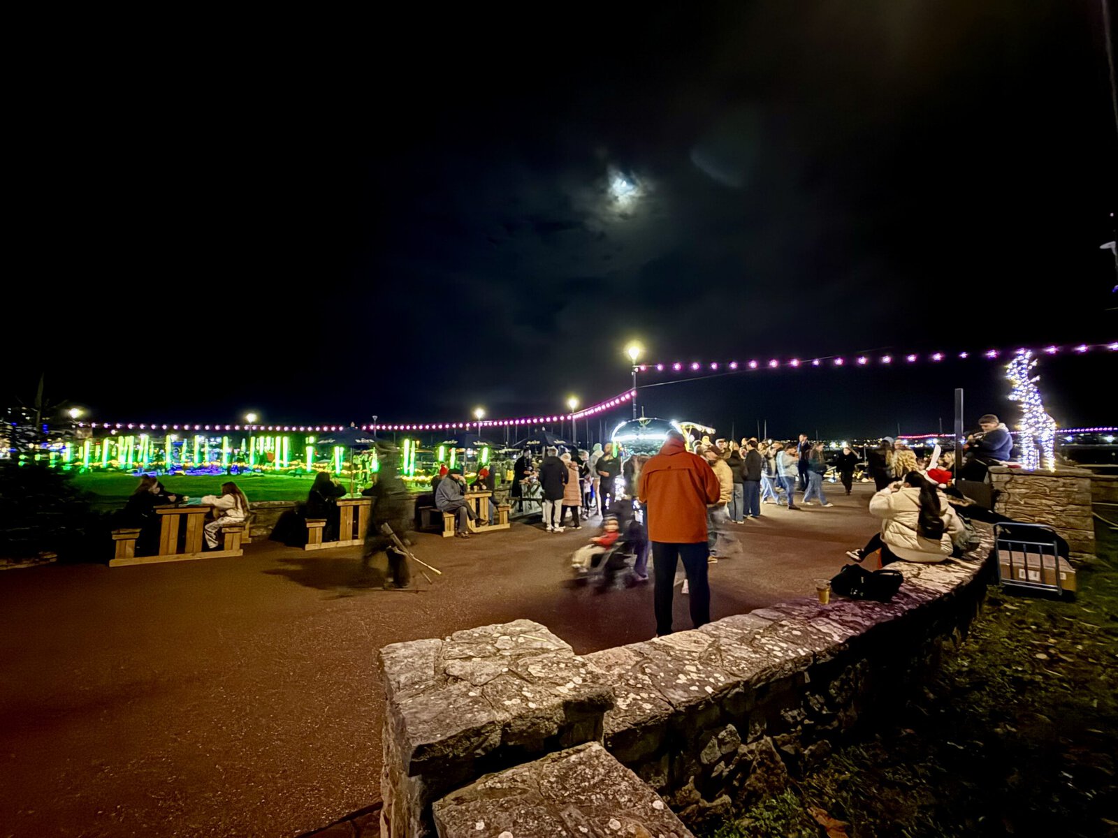Visitors enjoying illuminated displays along Torquay seafront during the Bay of Lights Illumination Trail.
