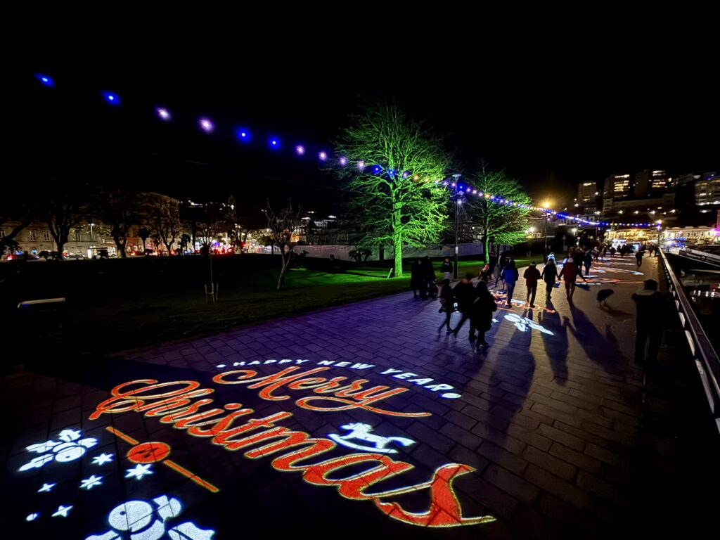 Merry Christmas light projection on the promenade during the Bay of Lights Illumination Trail in Torquay.