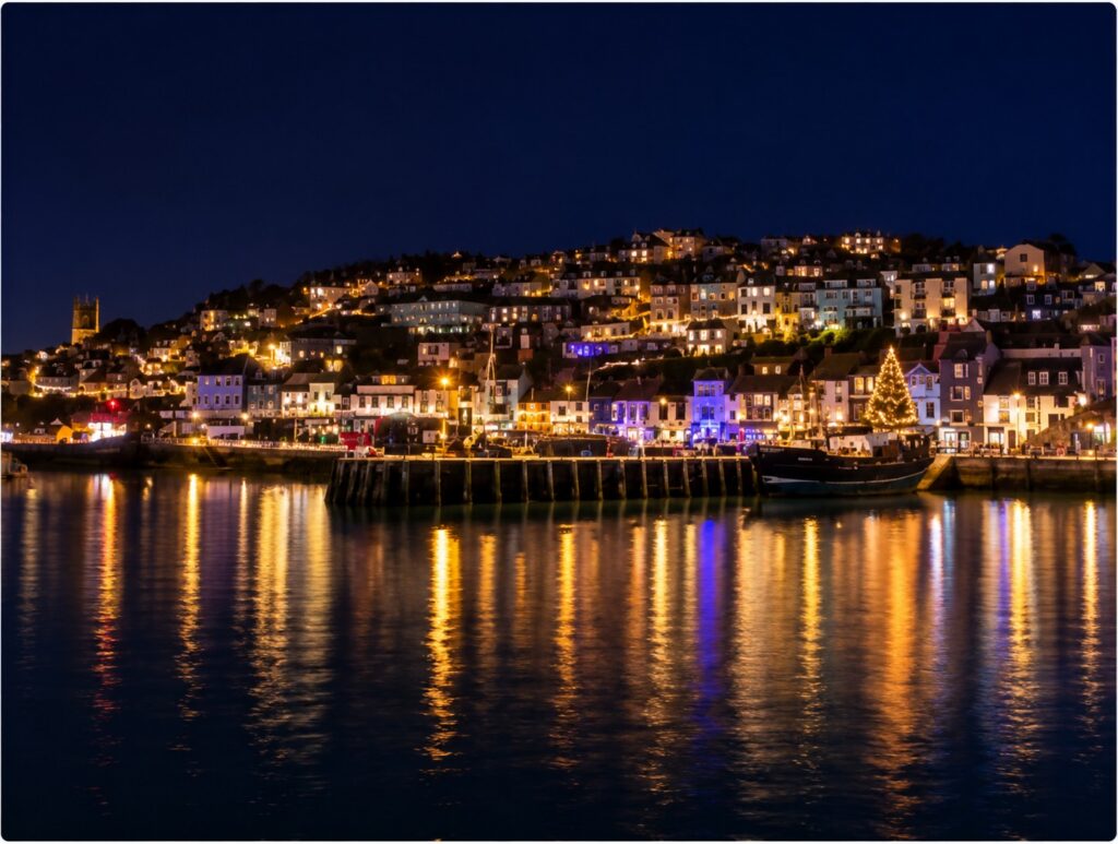 Stylised night-time view of Brixham Harbour illuminated with Christmas lights and festive reflections on the water.