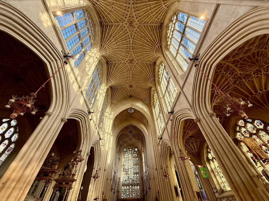 Interior of Bath Abbey showing its soaring Gothic arches, fan vaulted ceiling and stained glass windows
