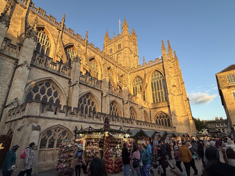 Bath Christmas Market in front of Bath Abbey, with festive stalls, lights and visitors enjoying one of the South West’s most popular winter events.