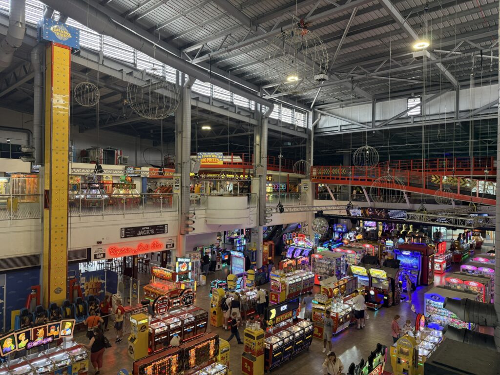 Inside the Grand Pier at Weston-super-Mare, with colourful arcade machines, amusement games and the tall indoor drop tower.