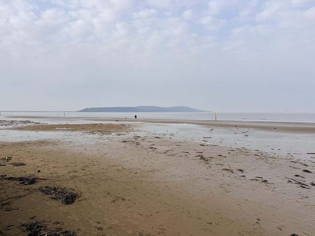 Low tide on Weston-super-Mare beach with wide sand flats stretching across Weston Bay and Brean Down in the background.