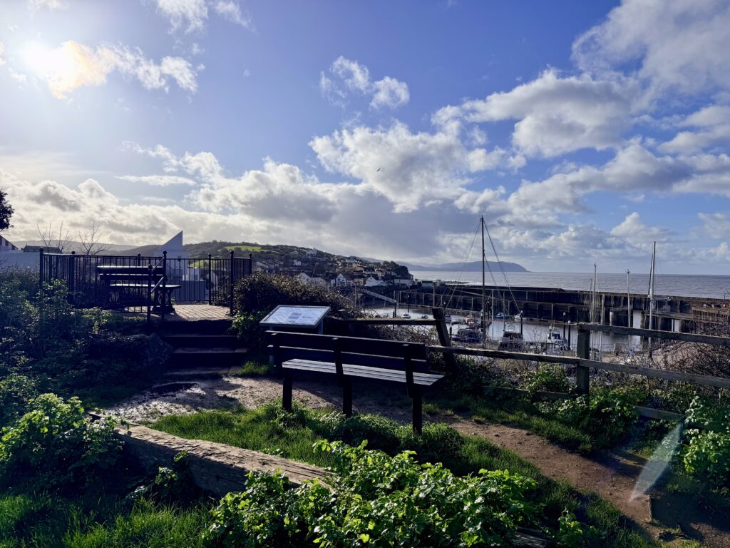 The Pleasure Ground in Watchet overlooking the harbour and marina, with seating area, viewpoint and Bristol Channel coastline beyond.
