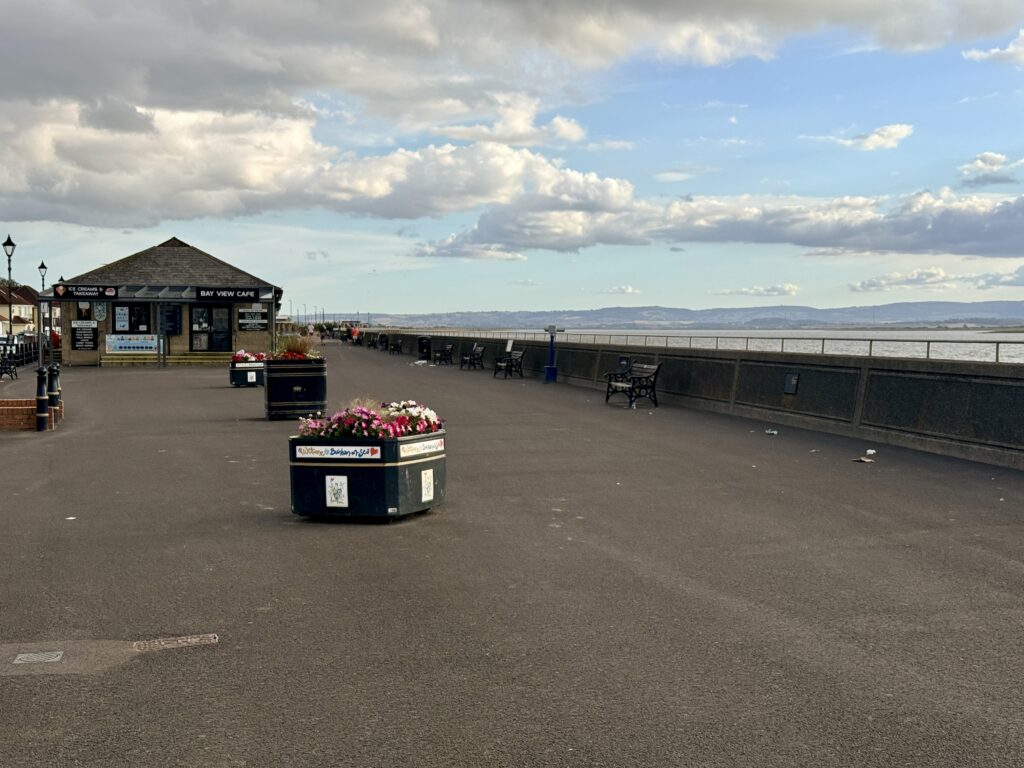 Burnham-on-Sea Esplanade with Bay View Café, flower planters, benches and views across the Bristol Channel.