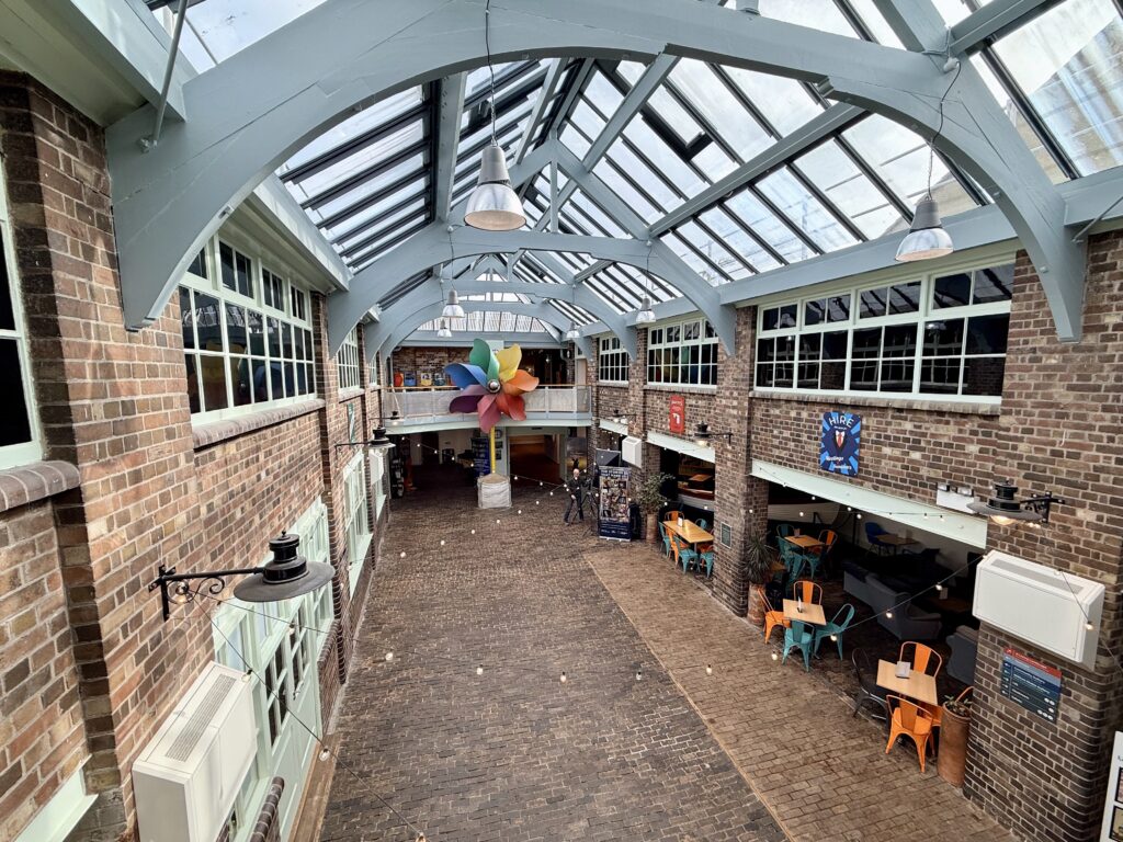 Interior courtyard of Weston Museum in Weston-super-Mare showing the glass roof, brick walls and café seating inside the historic North Somerset museum building.
