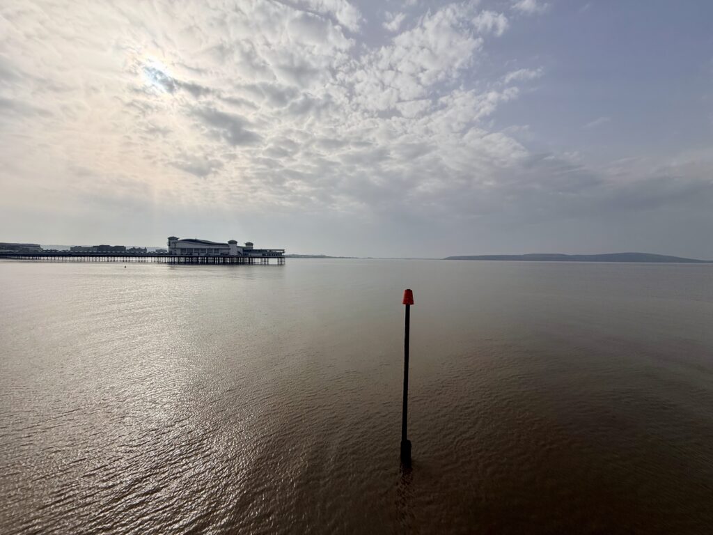 View across Weston Bay in Weston-super-Mare with the Grand Pier extending into the Bristol Channel, a popular seaside attraction for tourists visiting the Somerset coast.
