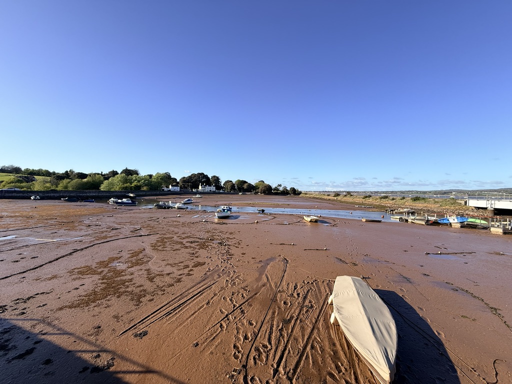 Cockwood Harbour on the Exe Estuary, Devon at low tide with moored boats, mudflats and village views towards Starcross