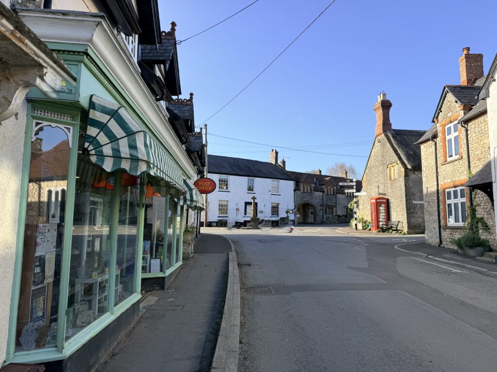 Church Street in Winsham, Somerset, showing traditional village buildings Winsham Village shop with green frontage.