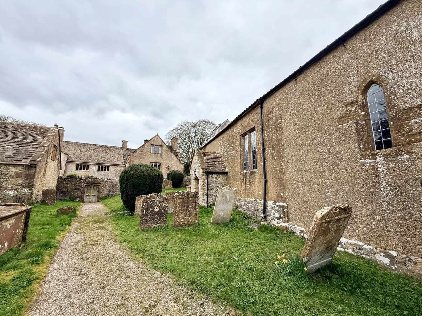 St Michael and All Angels Church and Wayford Manor, Wayford Somerset, showing historic churchyard, stone buildings and Tudor manor house.
