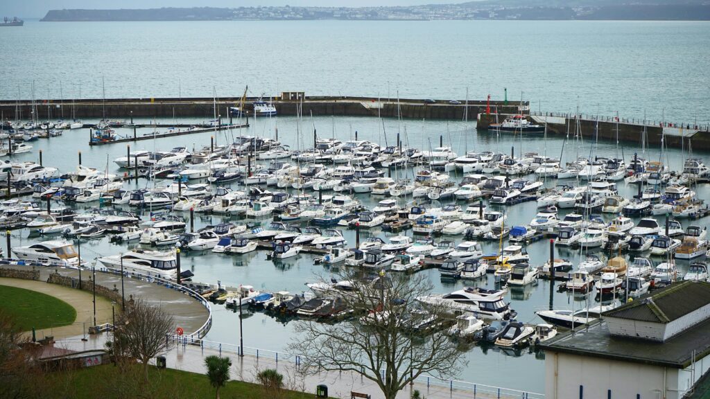 Torquay Harbour marina filled with boats on the English Riviera with views across Torbay coastline.
