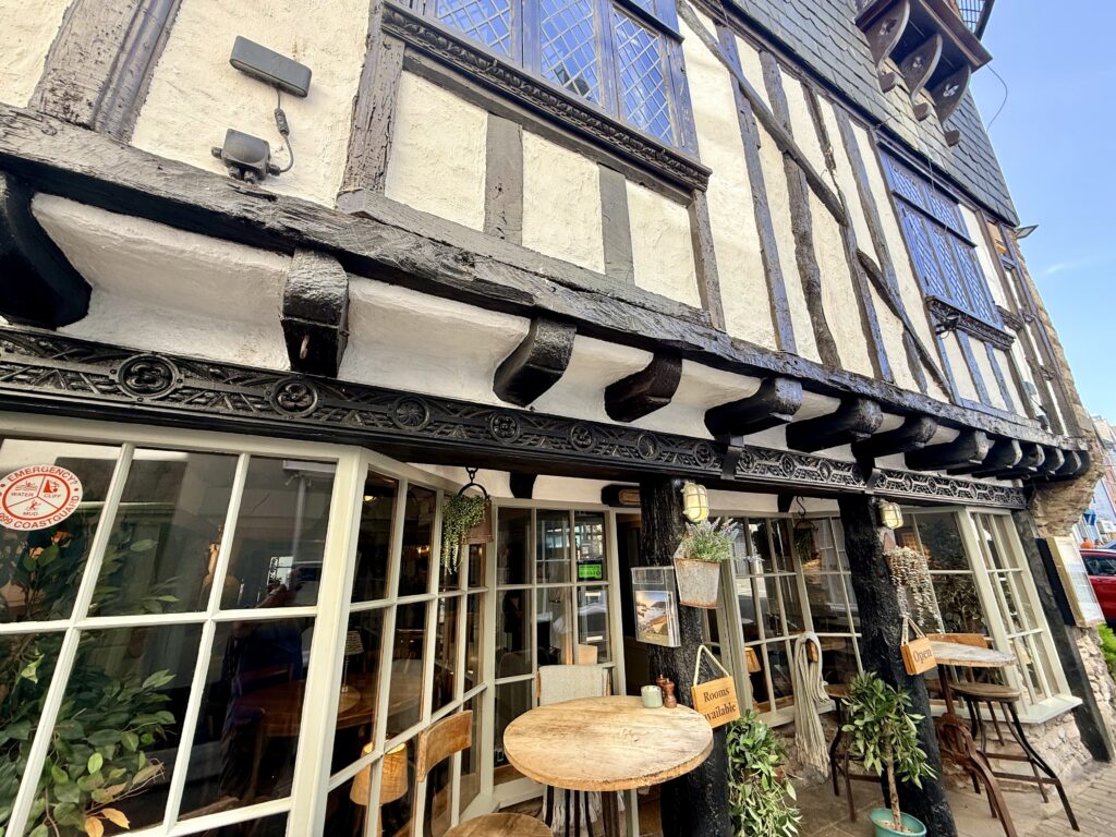Bayards Cove Inn in Dartmouth, showing the historic timber-framed frontage and outdoor tables near the waterfront.