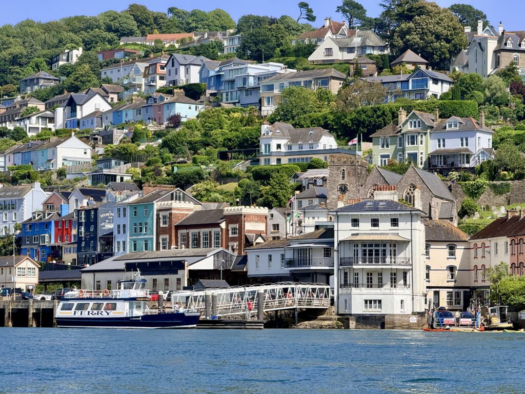 Kingswear waterfront with houses rising up the hillside above the River Dart, seen from across the water near Dartmouth in South Devon.