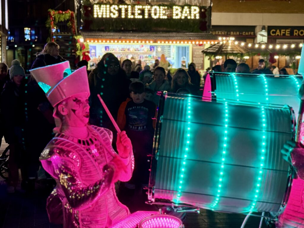 Illuminated drummers performing for Christmas crowds in Princesshay, Exeter