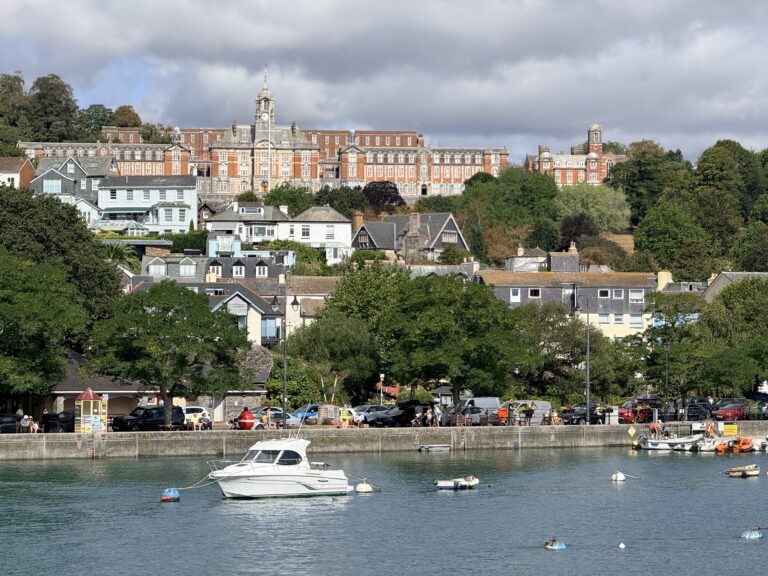 Britannia Royal Naval College overlooking houses and boats moored on the River Dart in Dartmouth