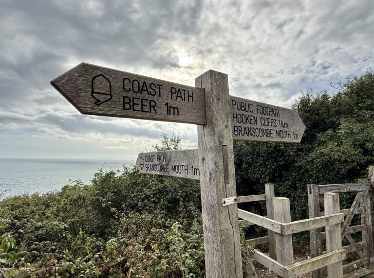 South West Coast Path signpost pointing towards Beer, Branscombe Mouth and Hooken Cliffs.