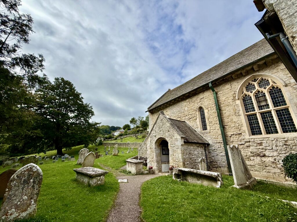 St Winifred’s Church and its historic churchyard surrounded by green countryside in Branscombe, Devon.