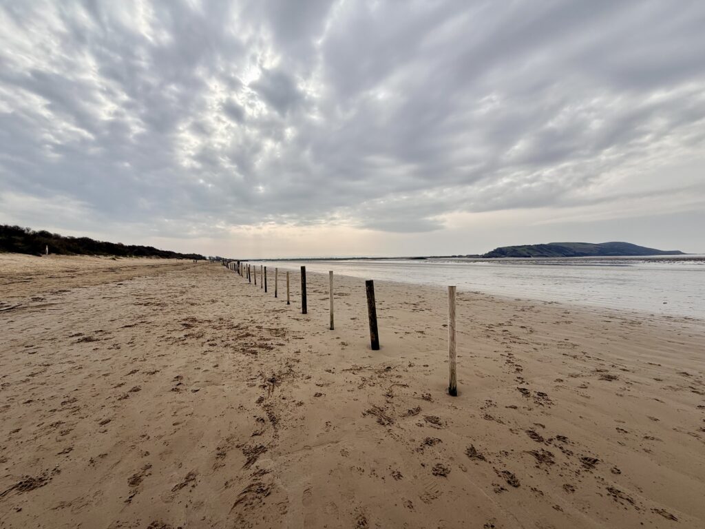 Uphill Sands near Weston-super-Mare, with a wide sandy shore beneath a cloudy sky.