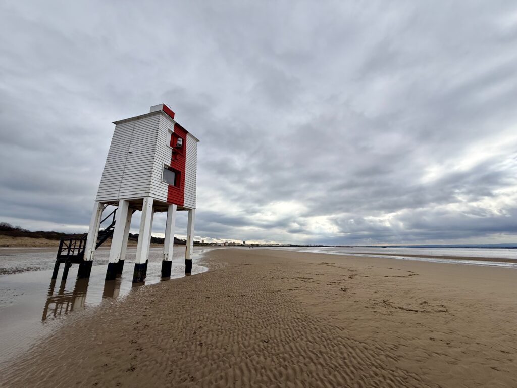 Burnham-on-Sea Low Lighthouse on the sandy beach, with a year-round dog-friendly section stretching north along the coast.