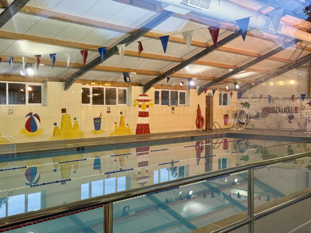 Indoor heated swimming pool at Stowford Farm Meadows with swimming lanes, beach-themed murals and changing facilities