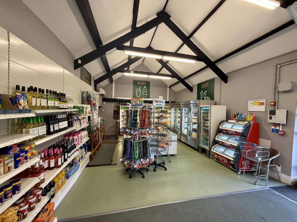 Interior of the Olde Farm Shop at Stowford Farm Meadows with groceries, wine, chilled drinks, ice cream and holiday essentials.