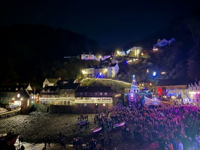 Clovelly harbour illuminated for the Christmas light switch-on with crowds gathered around the quay.