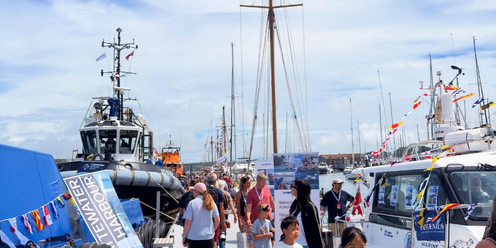 Boats and visitors gathered along the marina at Plymouth Boat Fest, with yachts and working vessels moored alongside the waterfront.