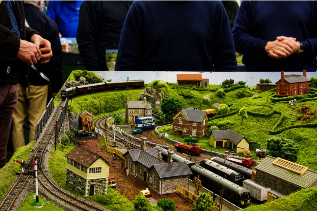 Model railway layout with miniature trains, tracks, buildings and countryside at Newton Abbot Library Railway Model Show.